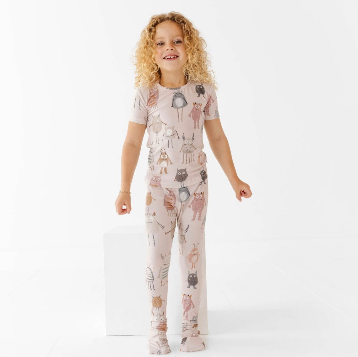 Child wearing a pajama set with animal print on a white background