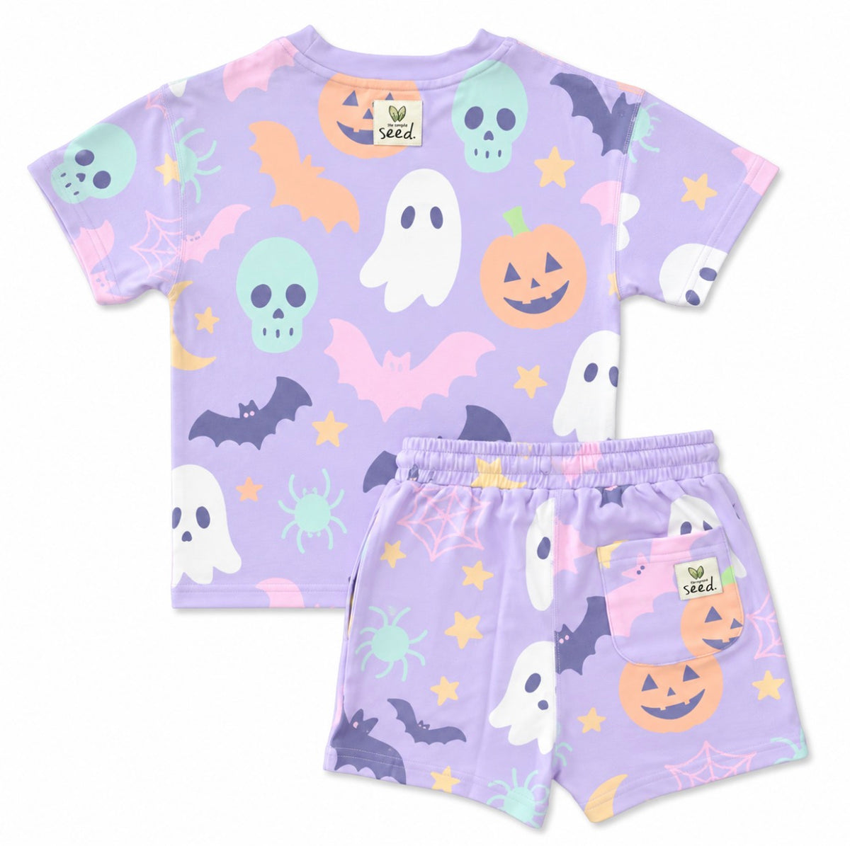 A children's two-piece pajama set featuring a short-sleeve top and matching shorts in light lavender purple, decorated with a colorful Halloween pattern of ghosts, pumpkins, bats, spiders, stars, and cobwebs. The brand name 'Sed.