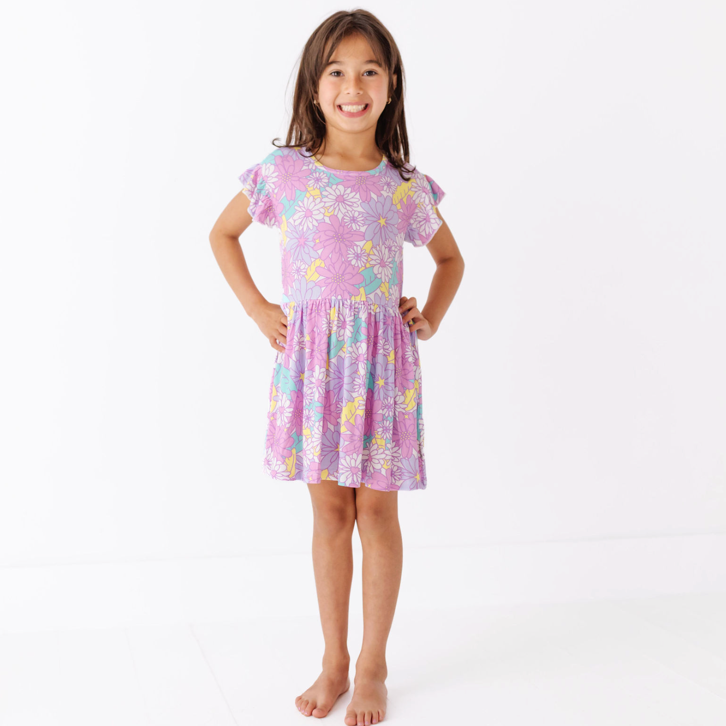 Young girl wearing a pink floral dress on a white background