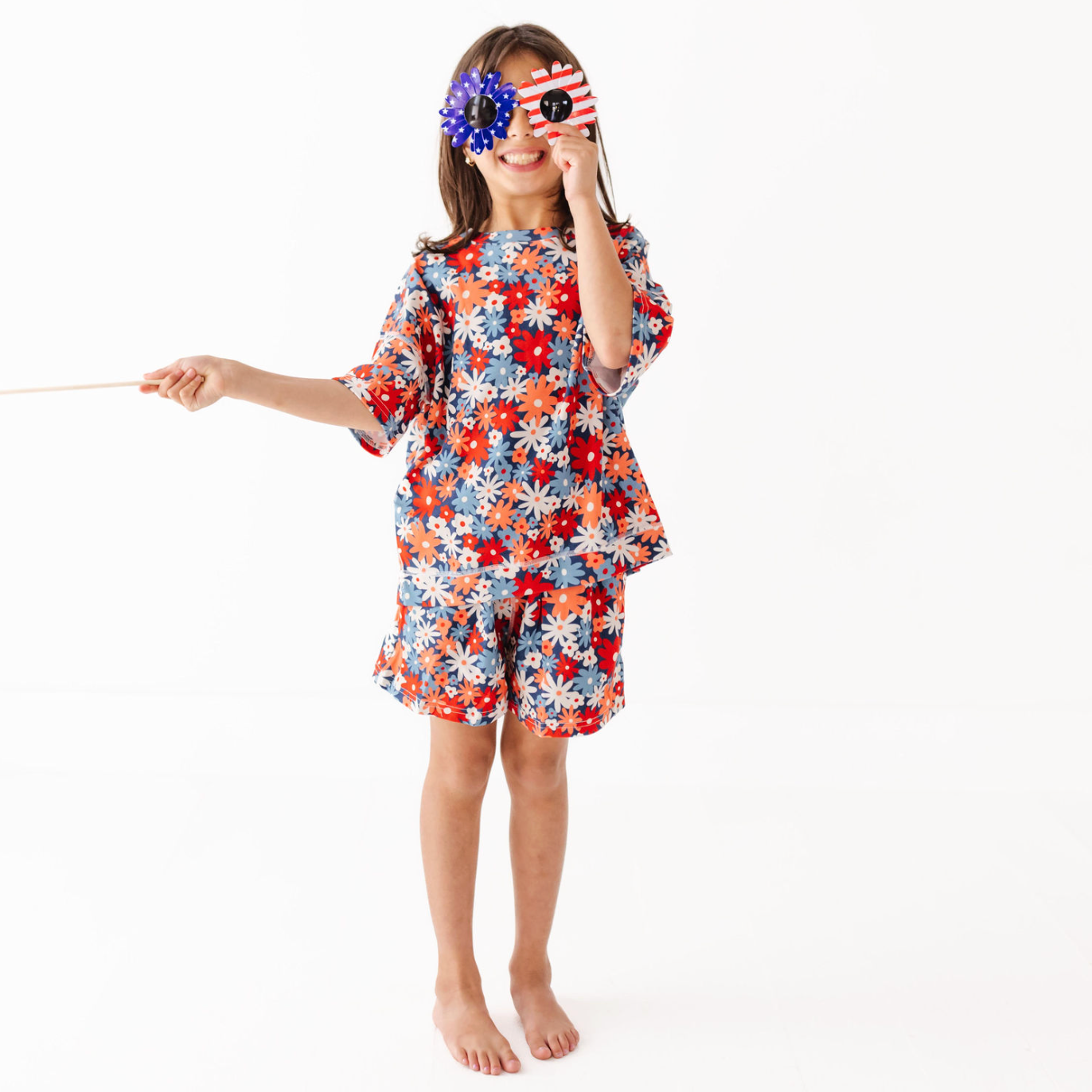 Child wearing a colorful floral outfit on a white background