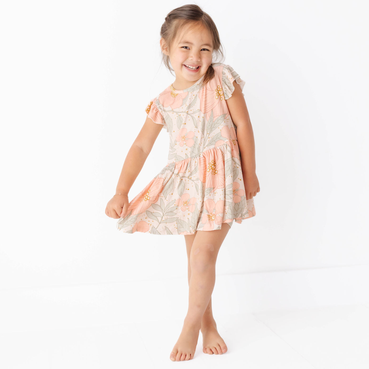 Young girl wearing a floral dress on a white background