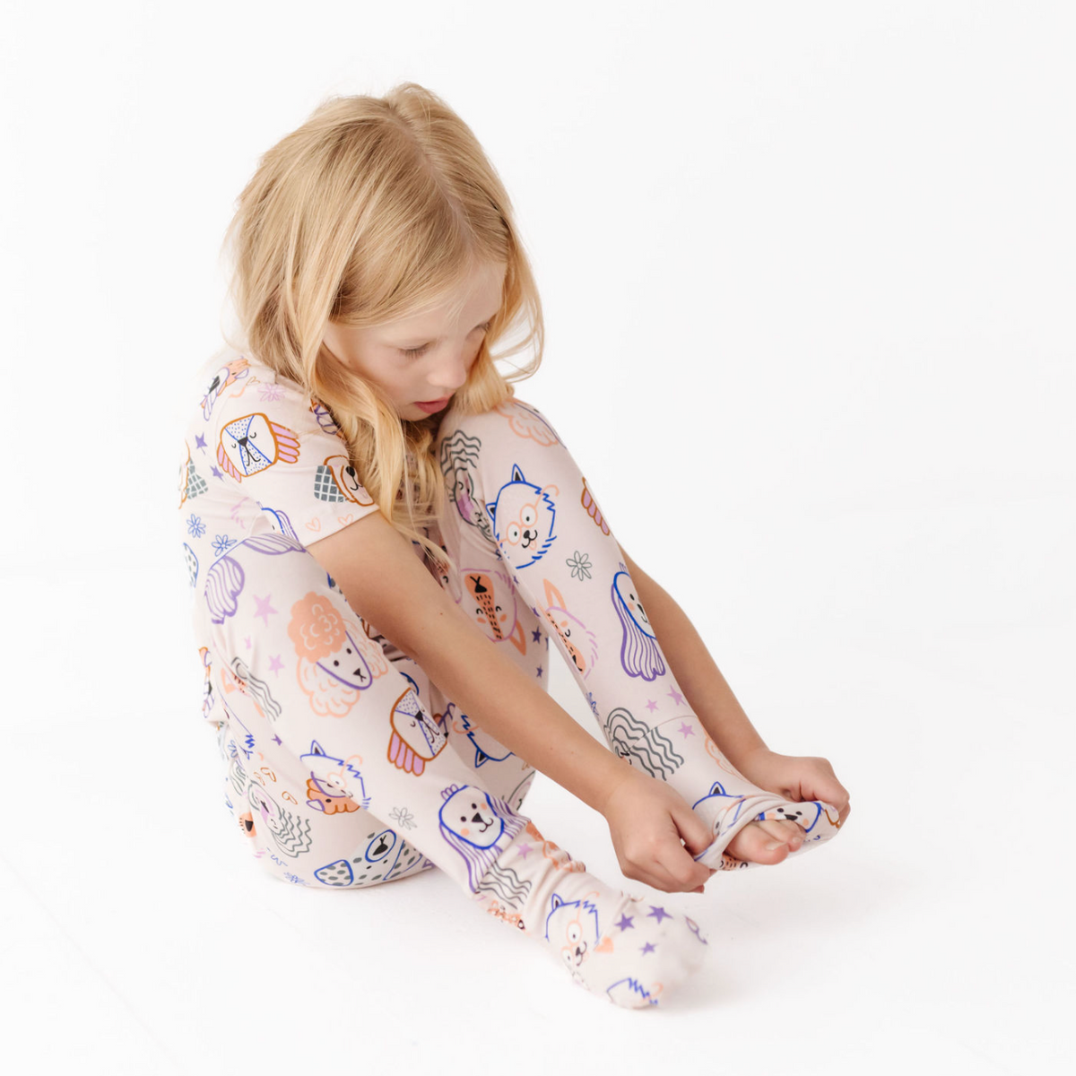 Child wearing pajama pants with colorful patterns on a white background