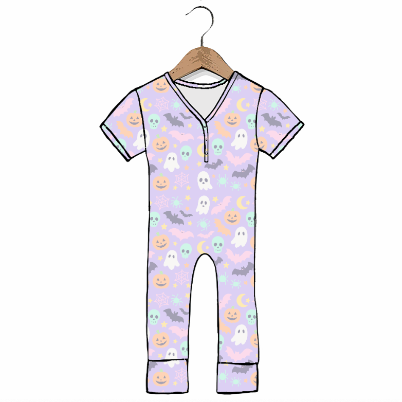 A short-sleeve baby jumpsuit with a light purple background and a Halloween print featuring ghosts, pumpkins, bats, and moons, hanging on a wooden hanger against a white background.
