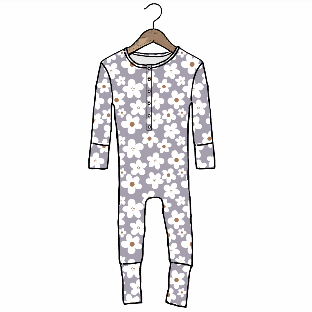 A long-sleeve baby footed one-piece pajama with a white daisy floral pattern on a light gray background, hanging on a wooden hanger against a plain white background.