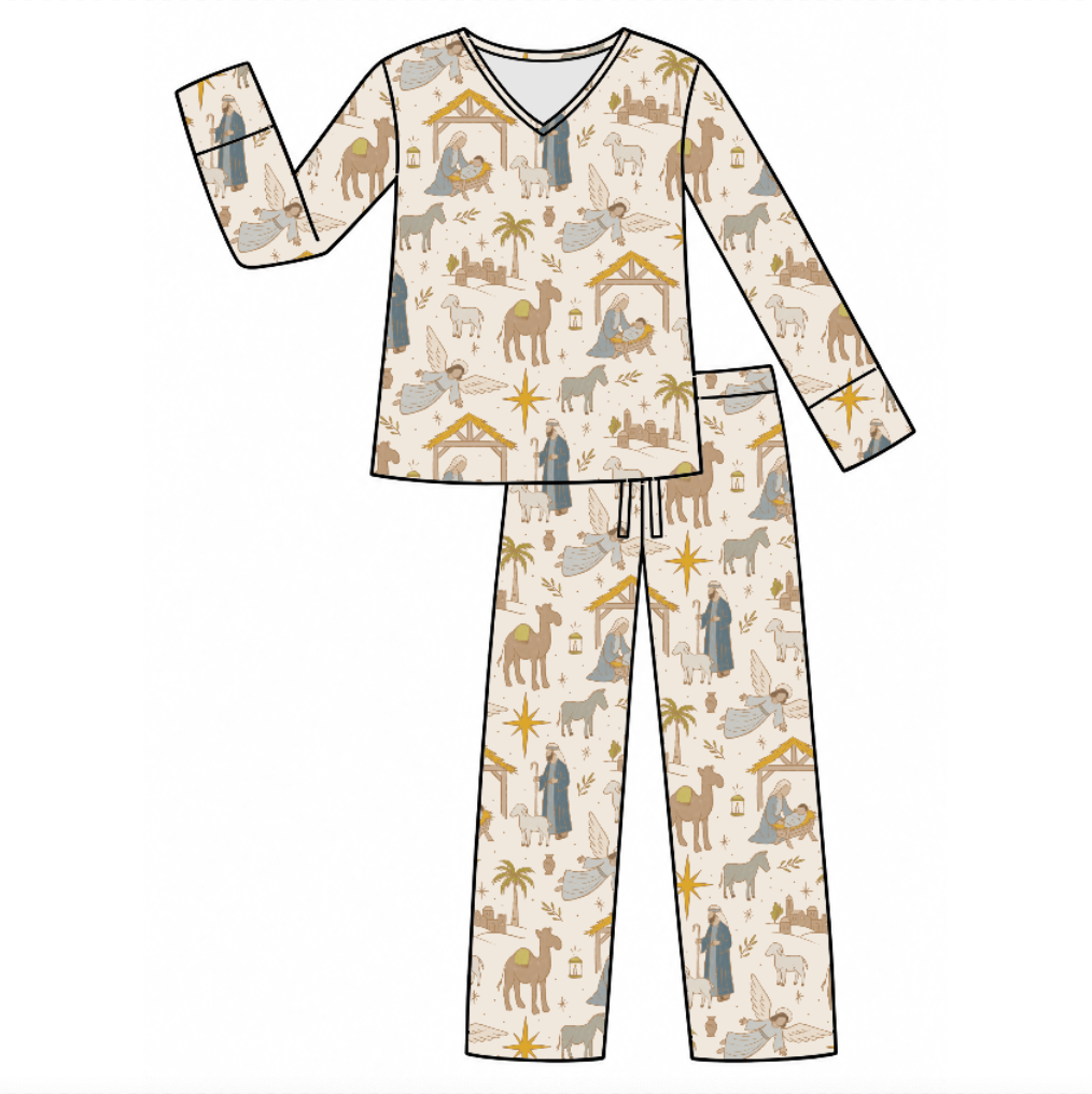 A flat-lay vector illustration of a two-piece pajama set featuring a long-sleeve V-neck top and matching pants. The pajamas have an all-over festive Christmas nativity print on a warm cream background, with illustrations of camels, wise men, shepherds, and stable houses in muted brown, gray, and gold tones.