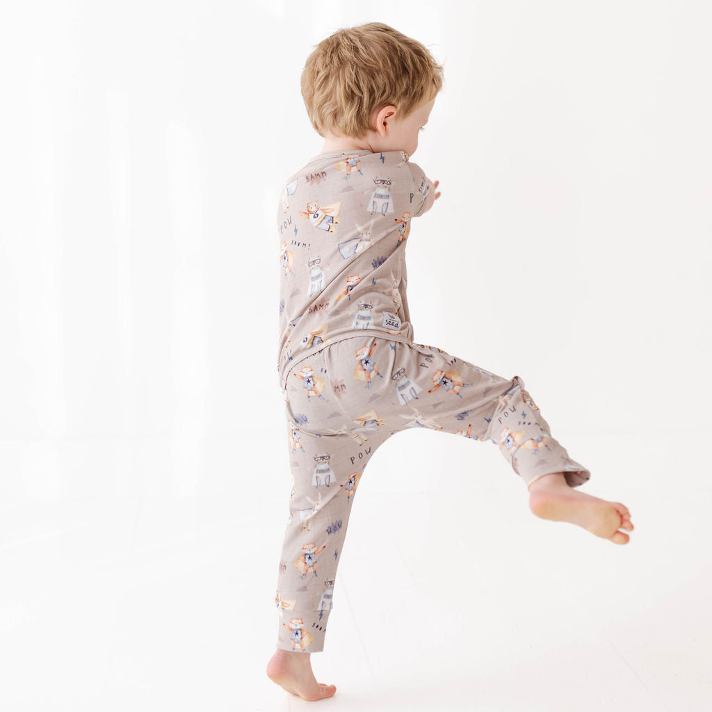 Child wearing a patterned onesie on a white background