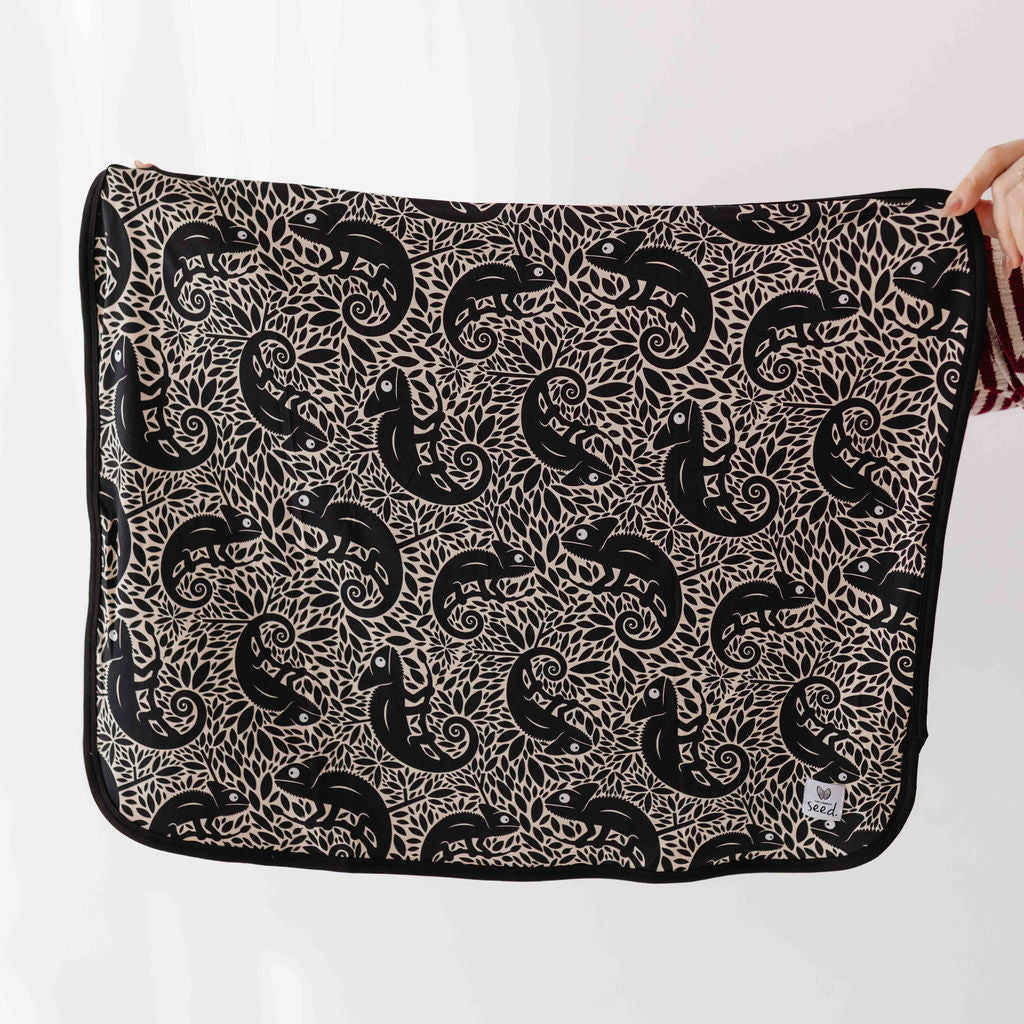 Patterned black and white fabric held by a person on a white background