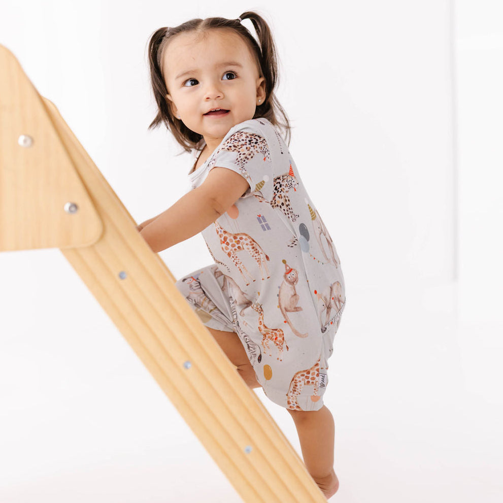Child climbing a wooden slide on a white background