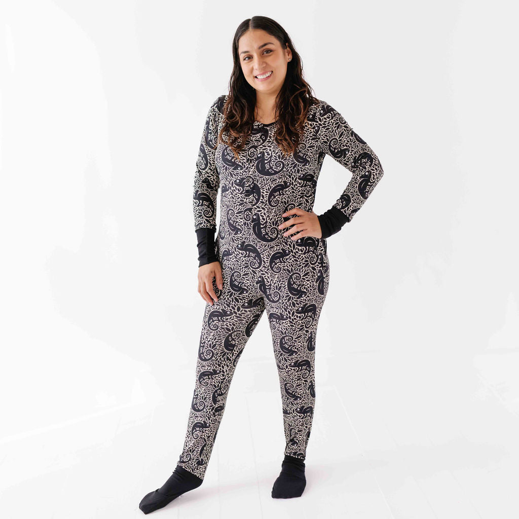 Person wearing a black and white patterned onesie on a white background