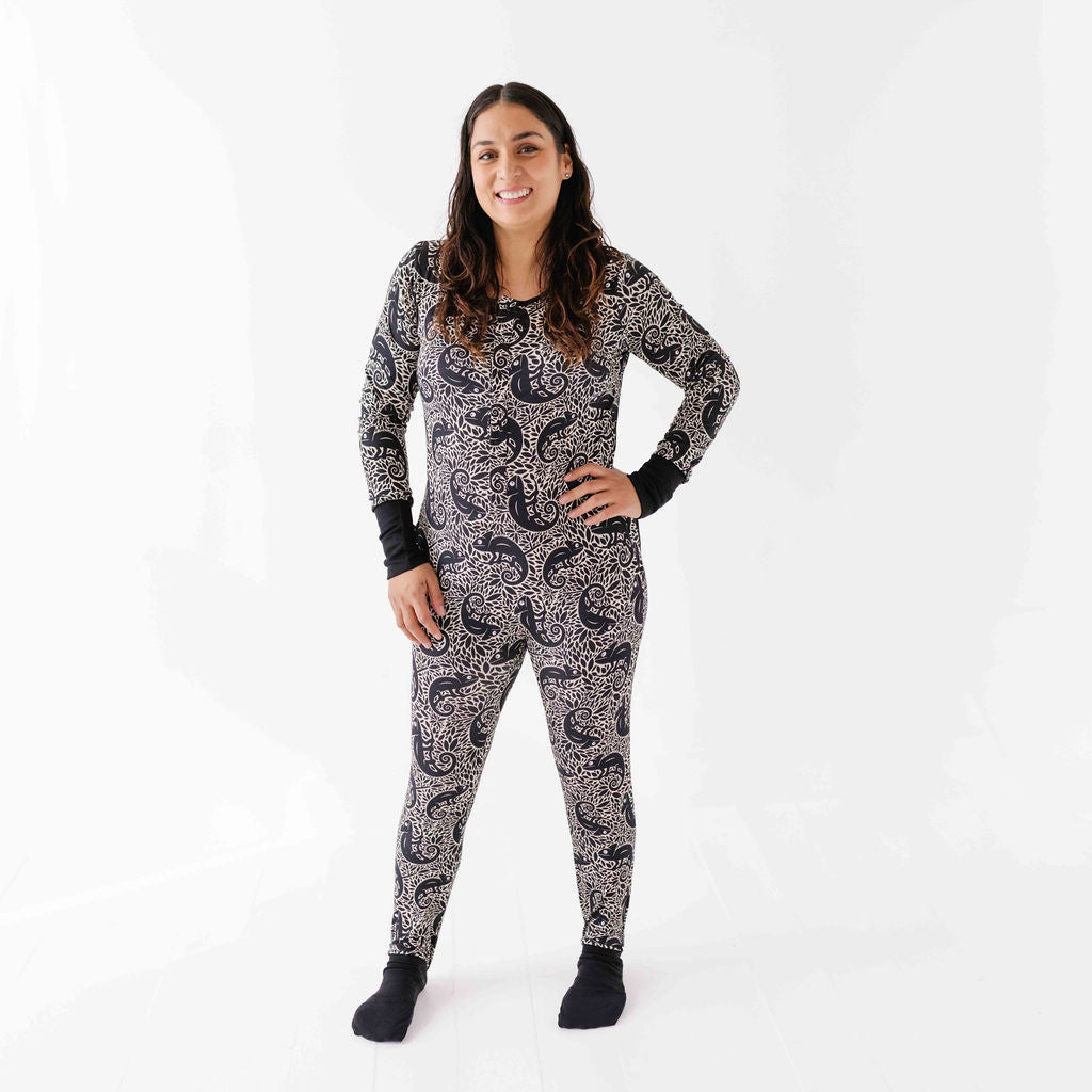 Woman wearing a black and white patterned onesie on a white background