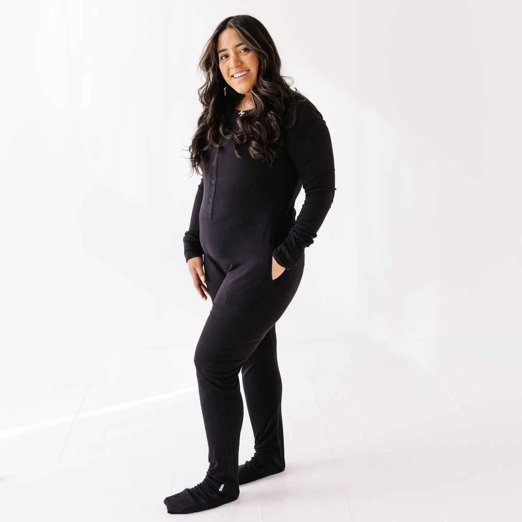 Woman wearing a black onesie on a white background