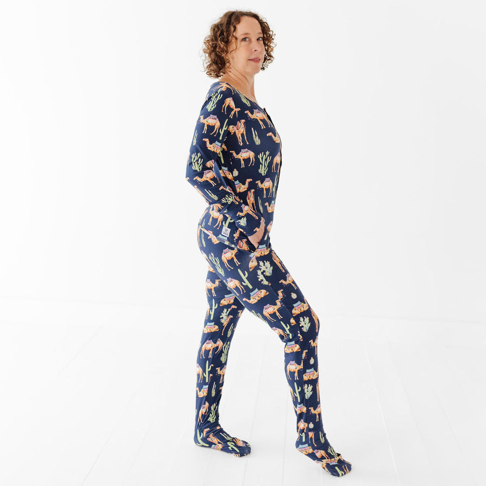 Person wearing a navy blue onesie with colorful animal pattern on a white background