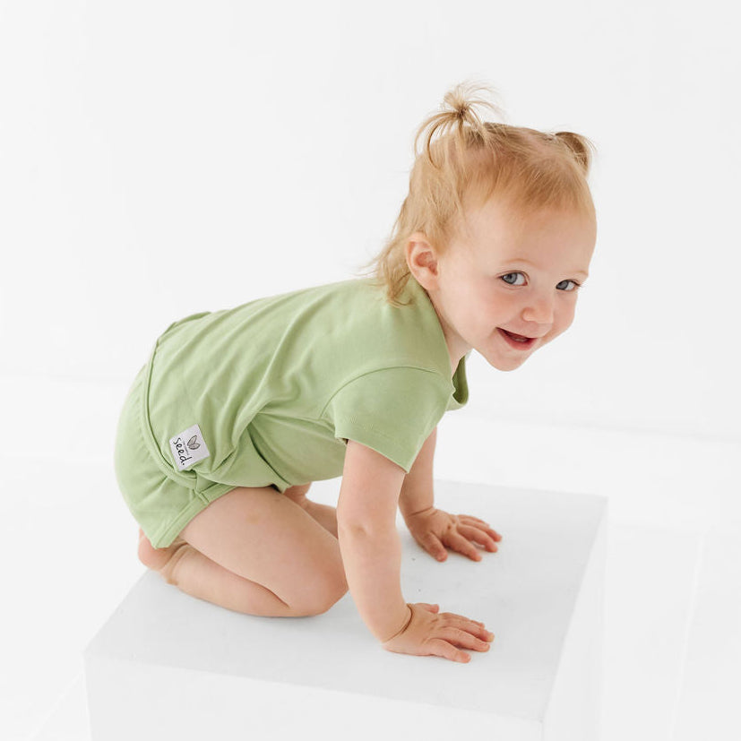 Baby in a green outfit on a white background