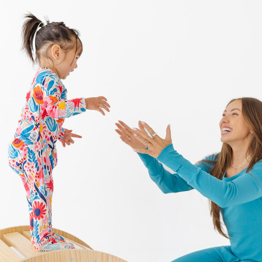 Woman and child in colorful pajamas on a white background