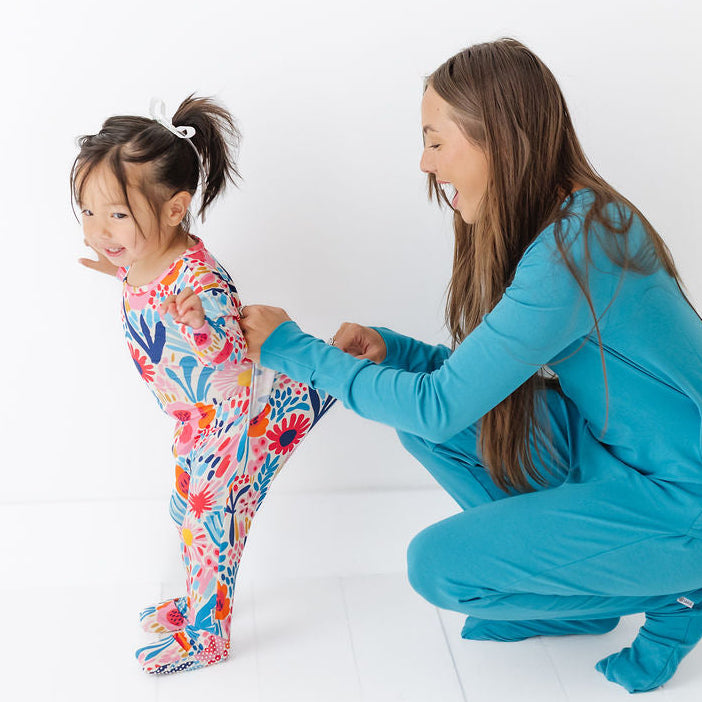 Woman and child in colorful onesies on a white background
