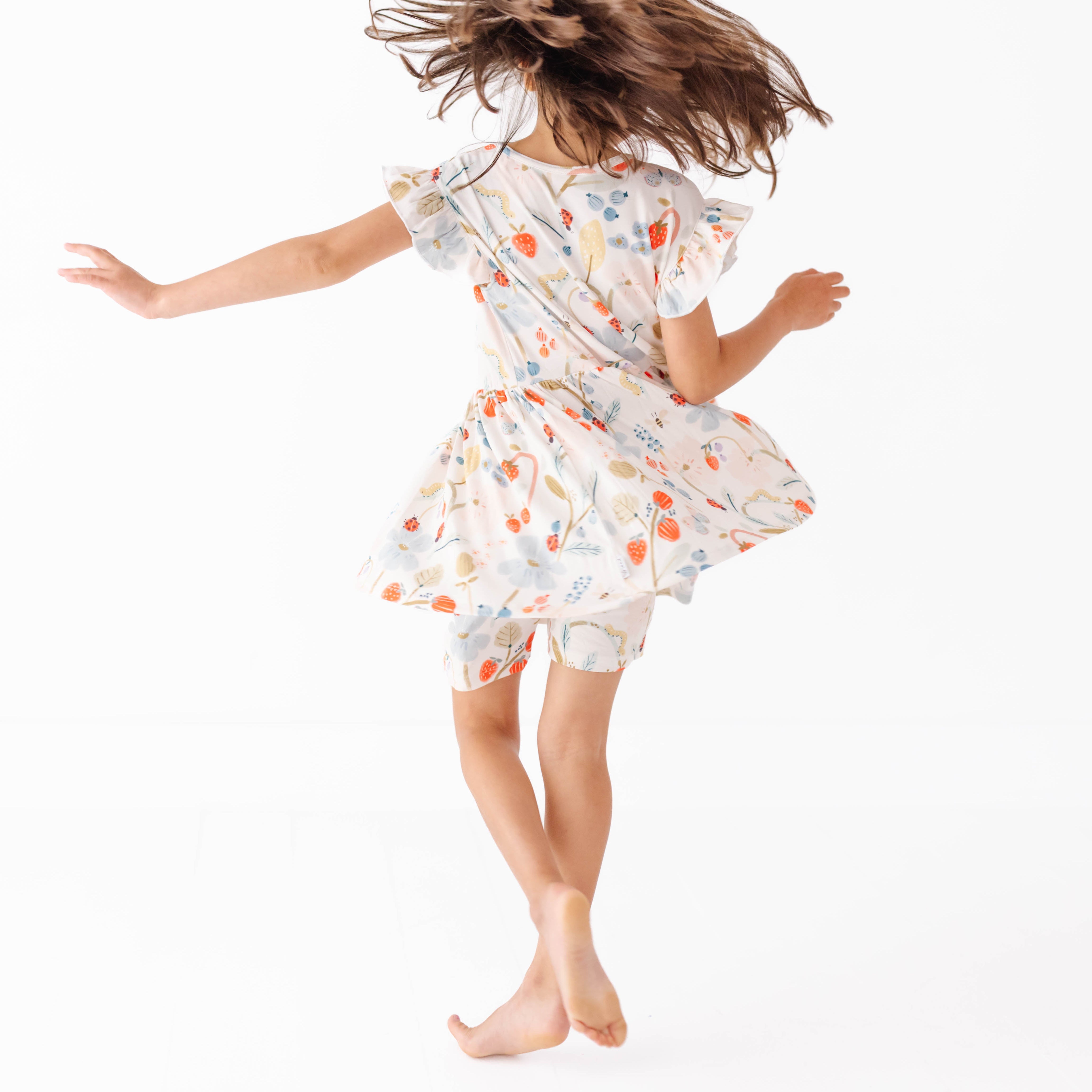 Child wearing a floral dress on a white background