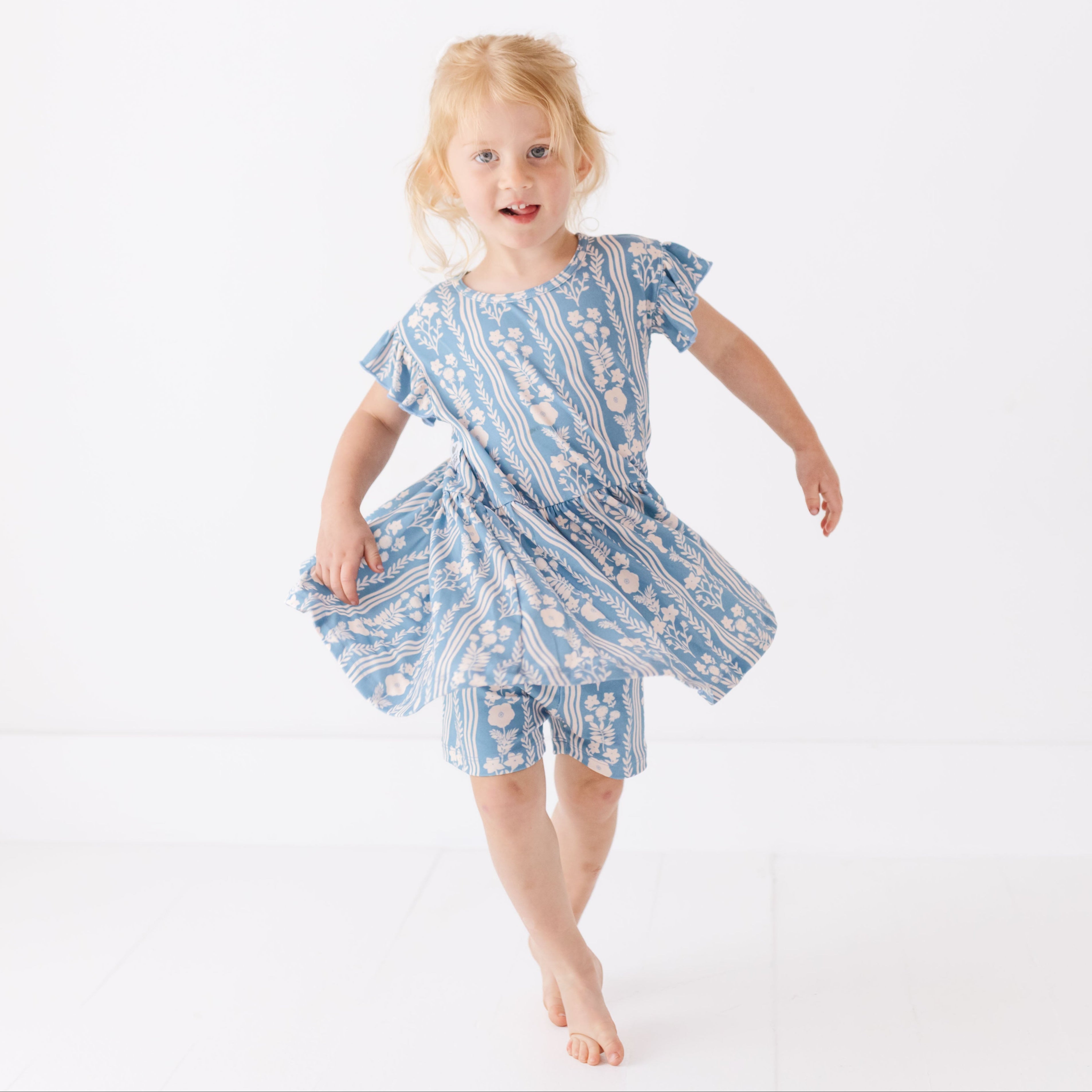 Young girl wearing a blue floral dress on a white background