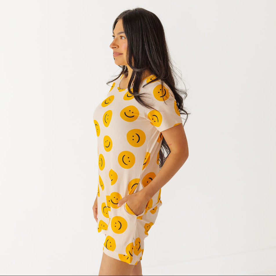 Woman wearing a dress with smiley face pattern on a white background