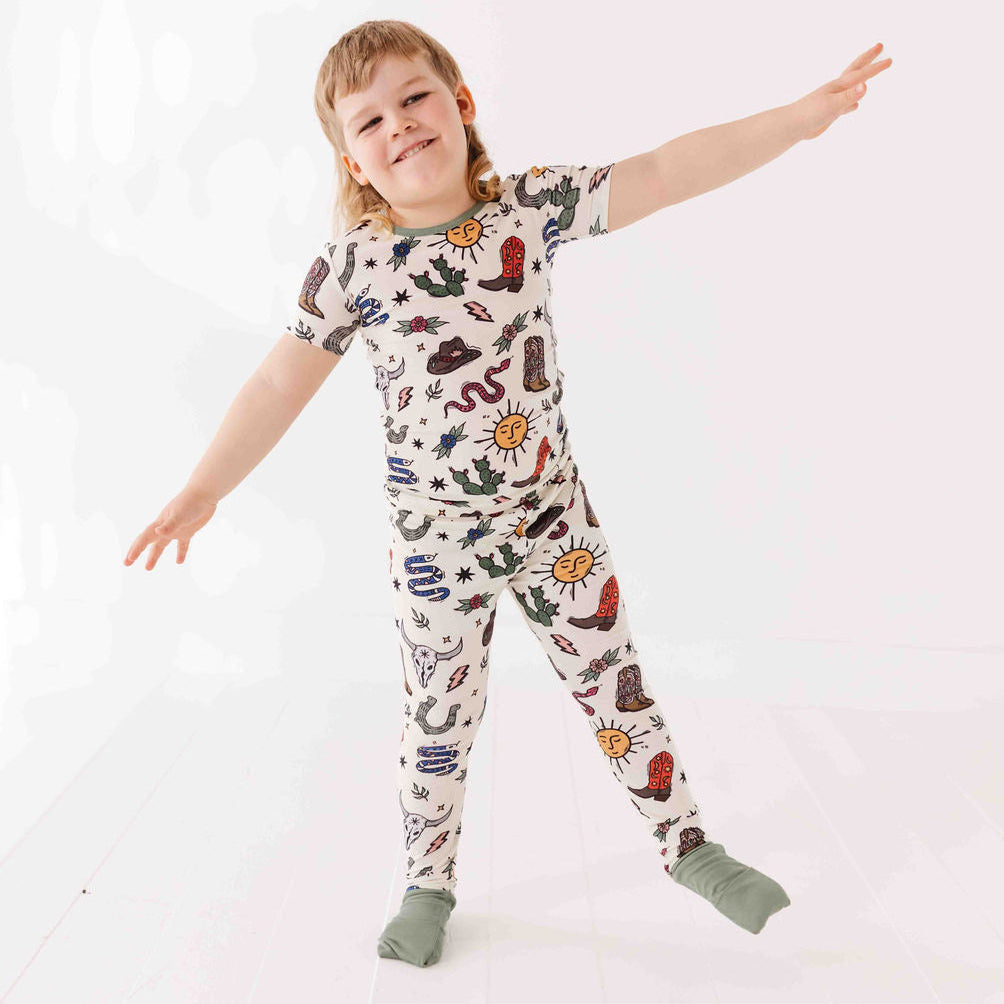 Child wearing a colorful patterned onesie on a white background