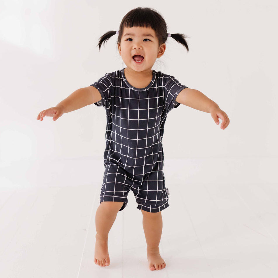Child wearing a black and white checkered outfit on a white background