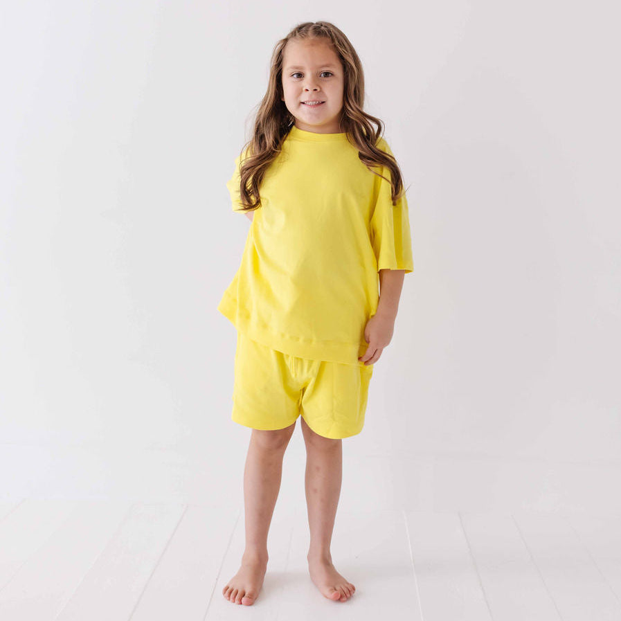 Young girl wearing a yellow outfit on a white background