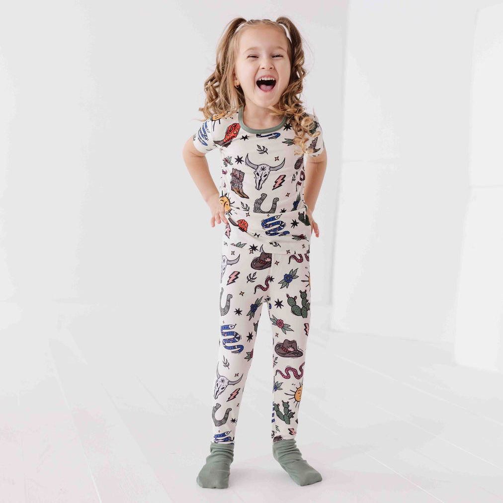 Child wearing a colorful patterned onesie on a white background