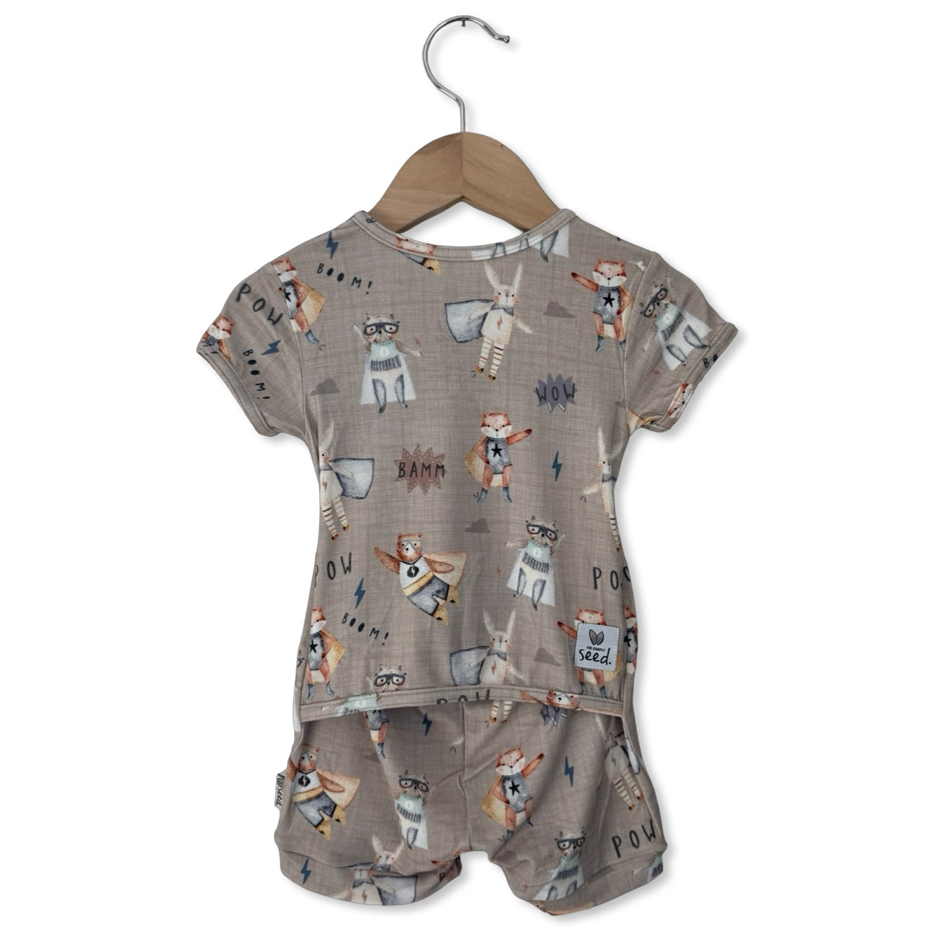 Children's outfit with patterned top and shorts on a hanger against a white background
