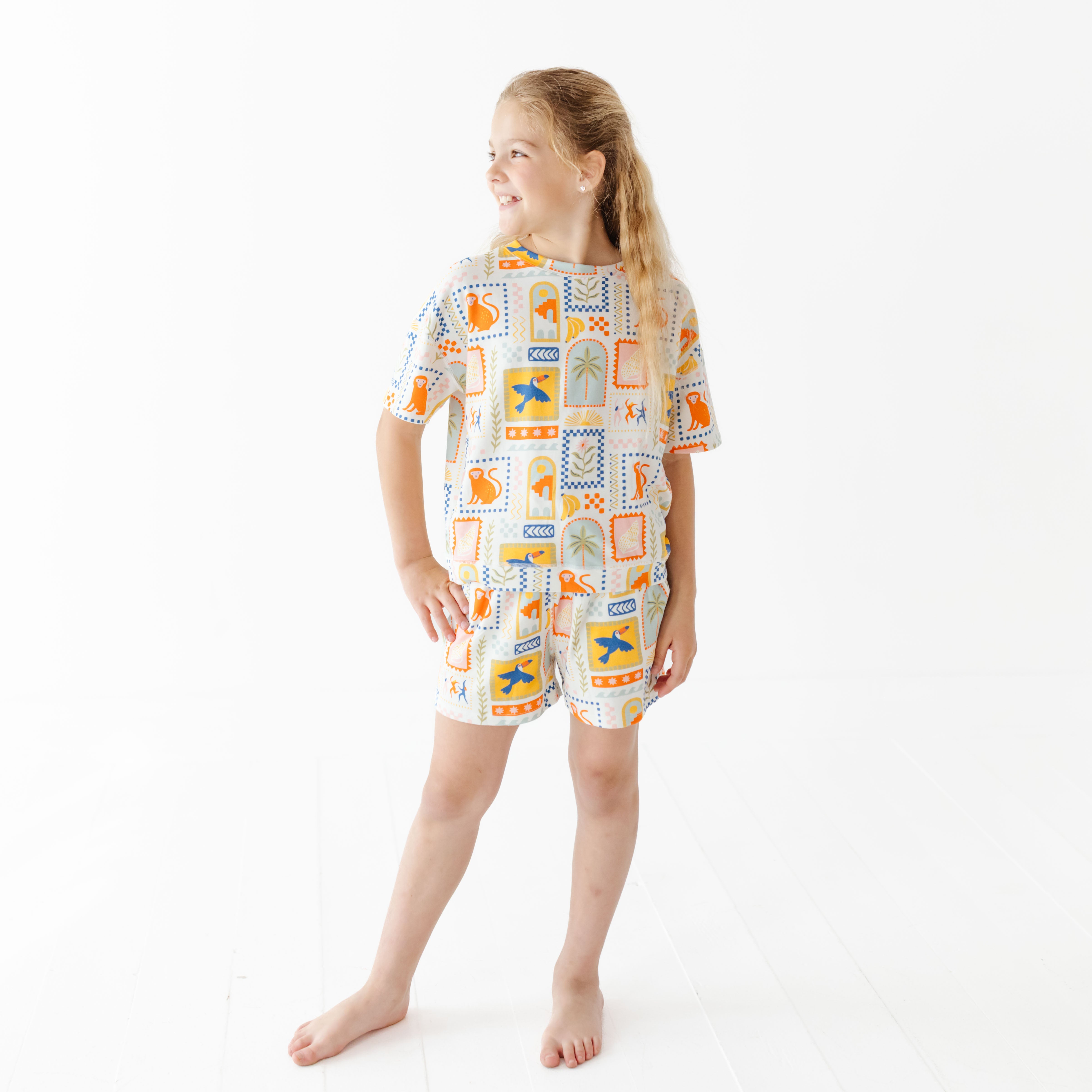 Young girl wearing a patterned pajama set on a white background