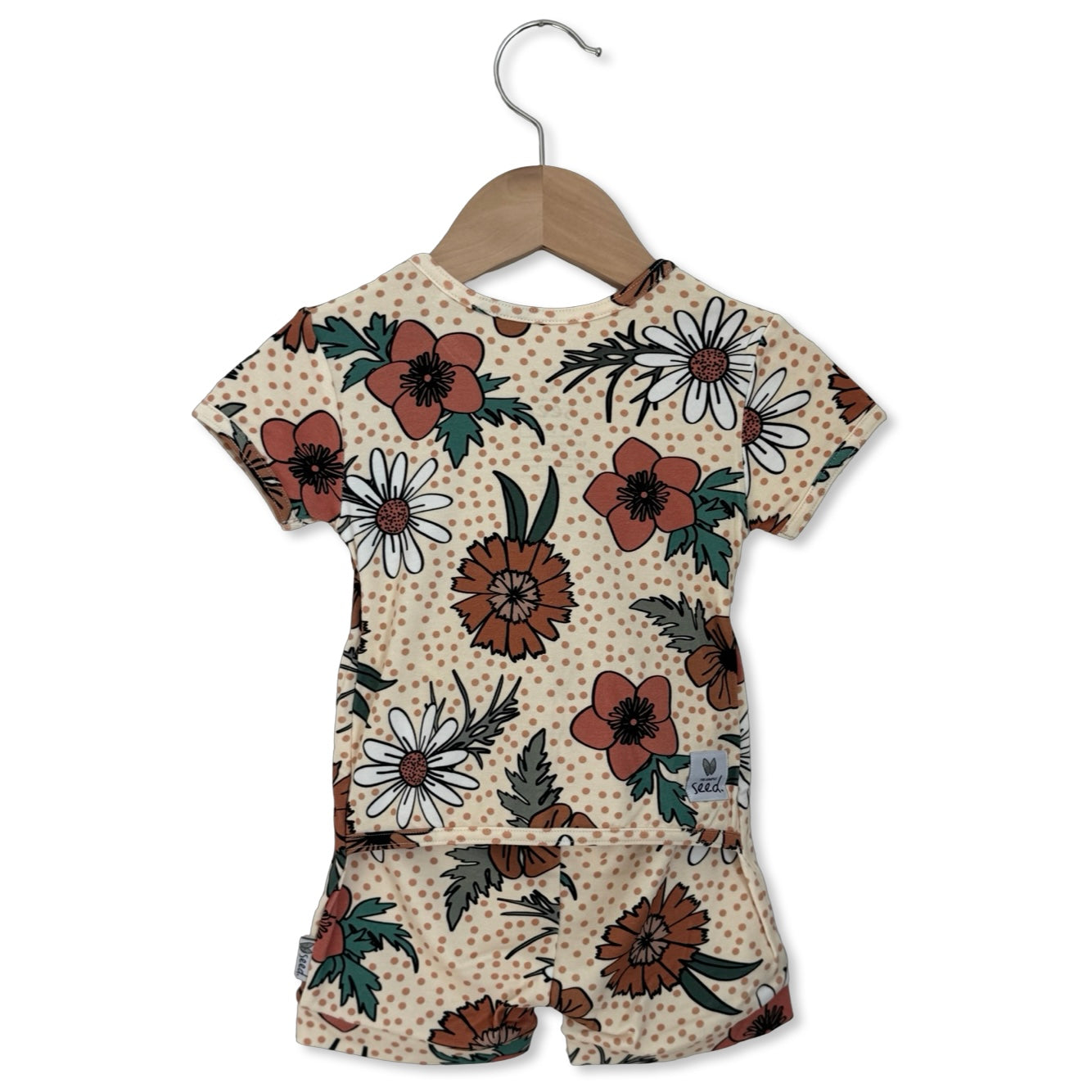 Children's floral outfit on a hanger against a white background