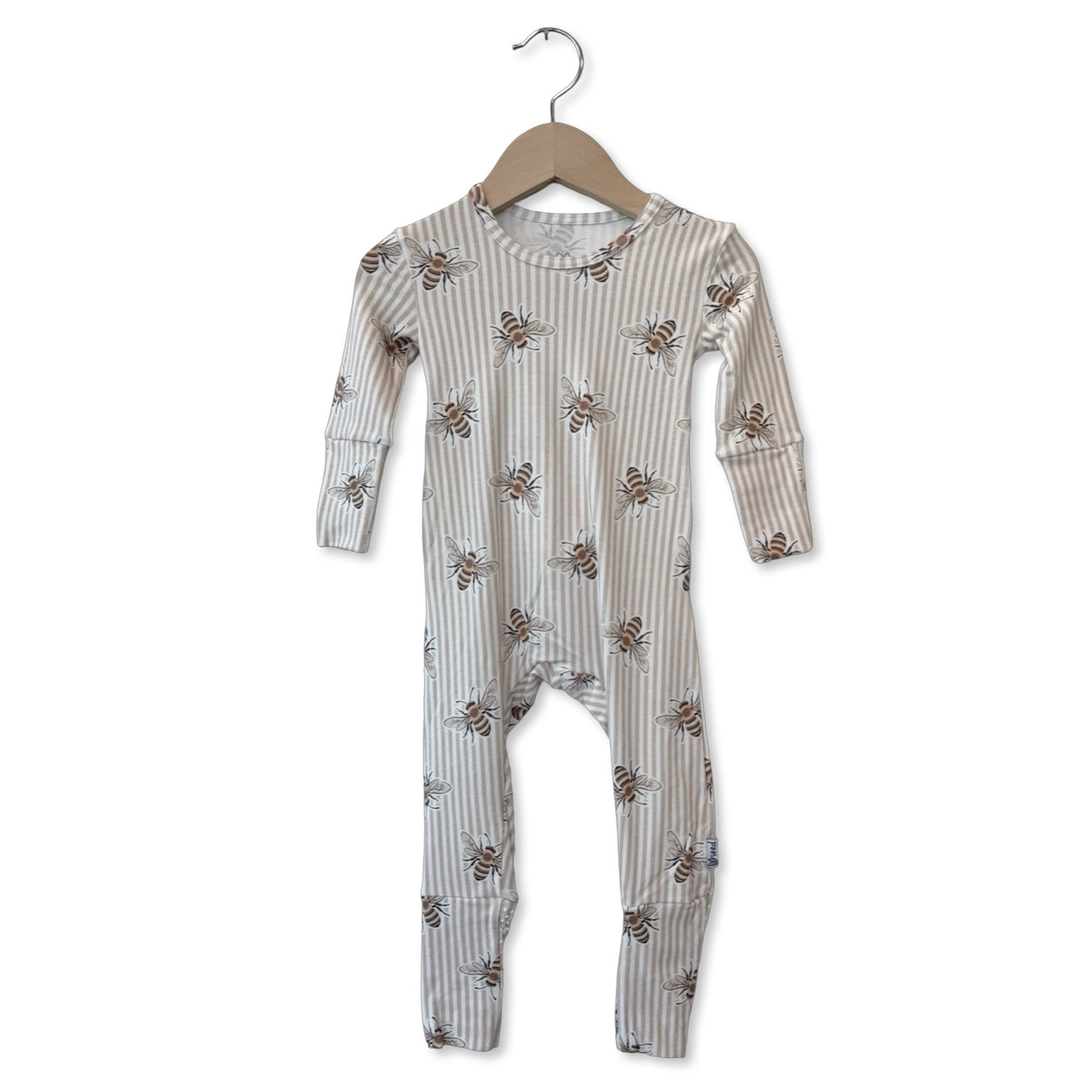 Children's onesie with bee pattern on a hanger against a white background