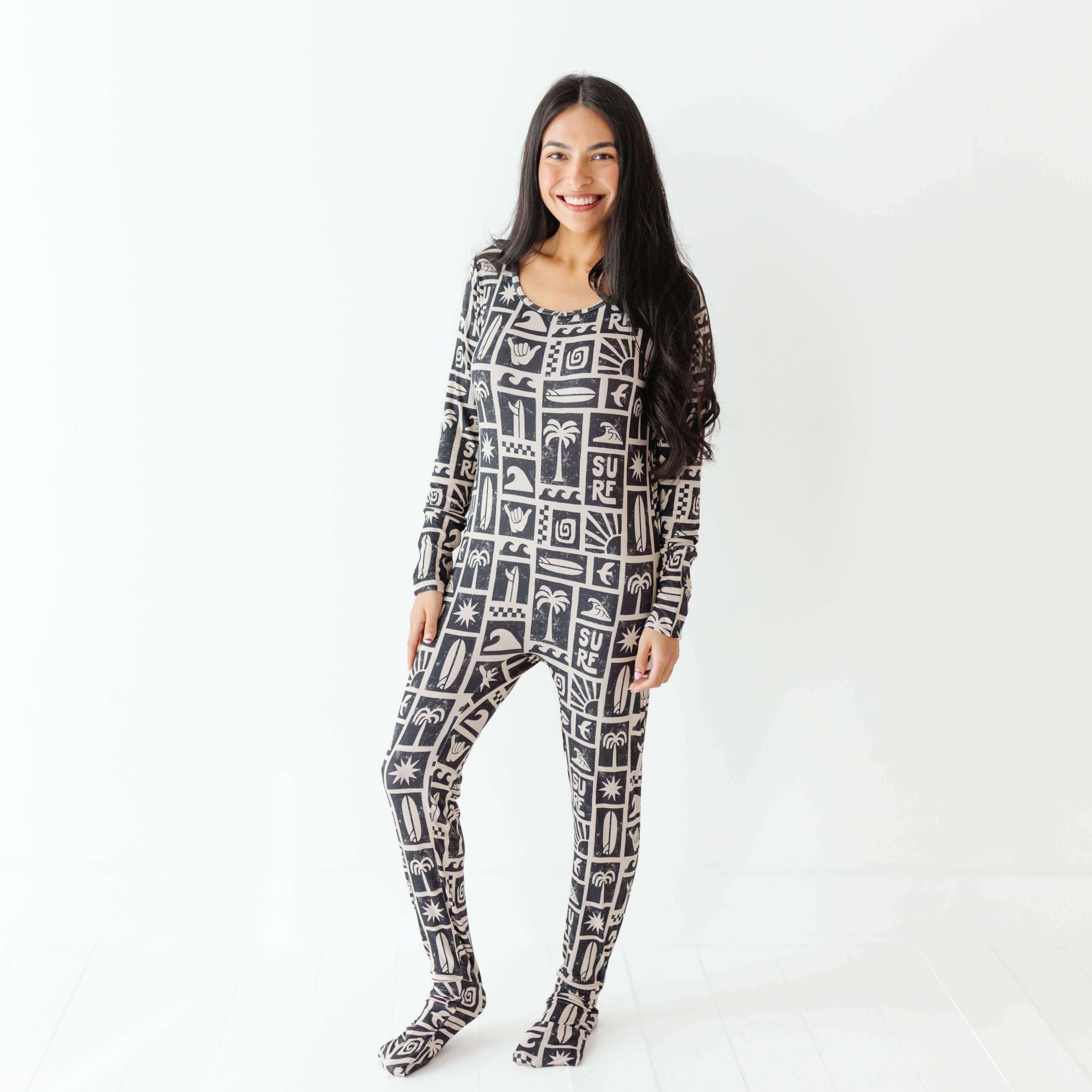 Woman wearing a black and white patterned onesie on a white background