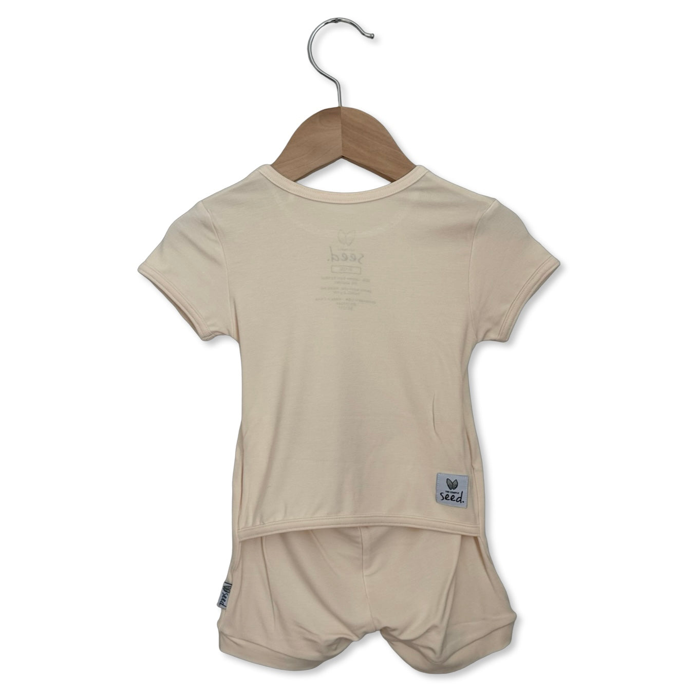 Beige t-shirt and shorts set on a hanger against a white background
