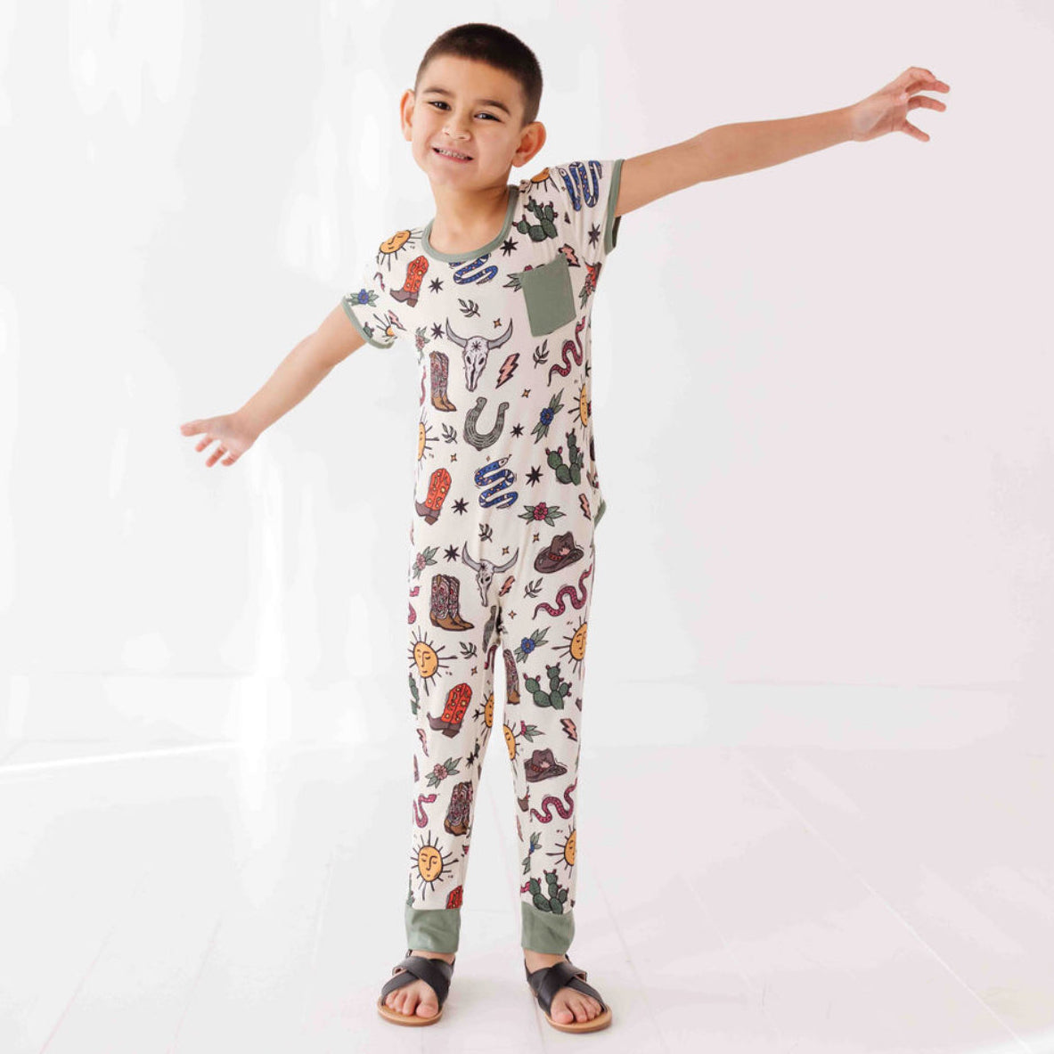 Child wearing a colorful pajama set with various patterns on a white background