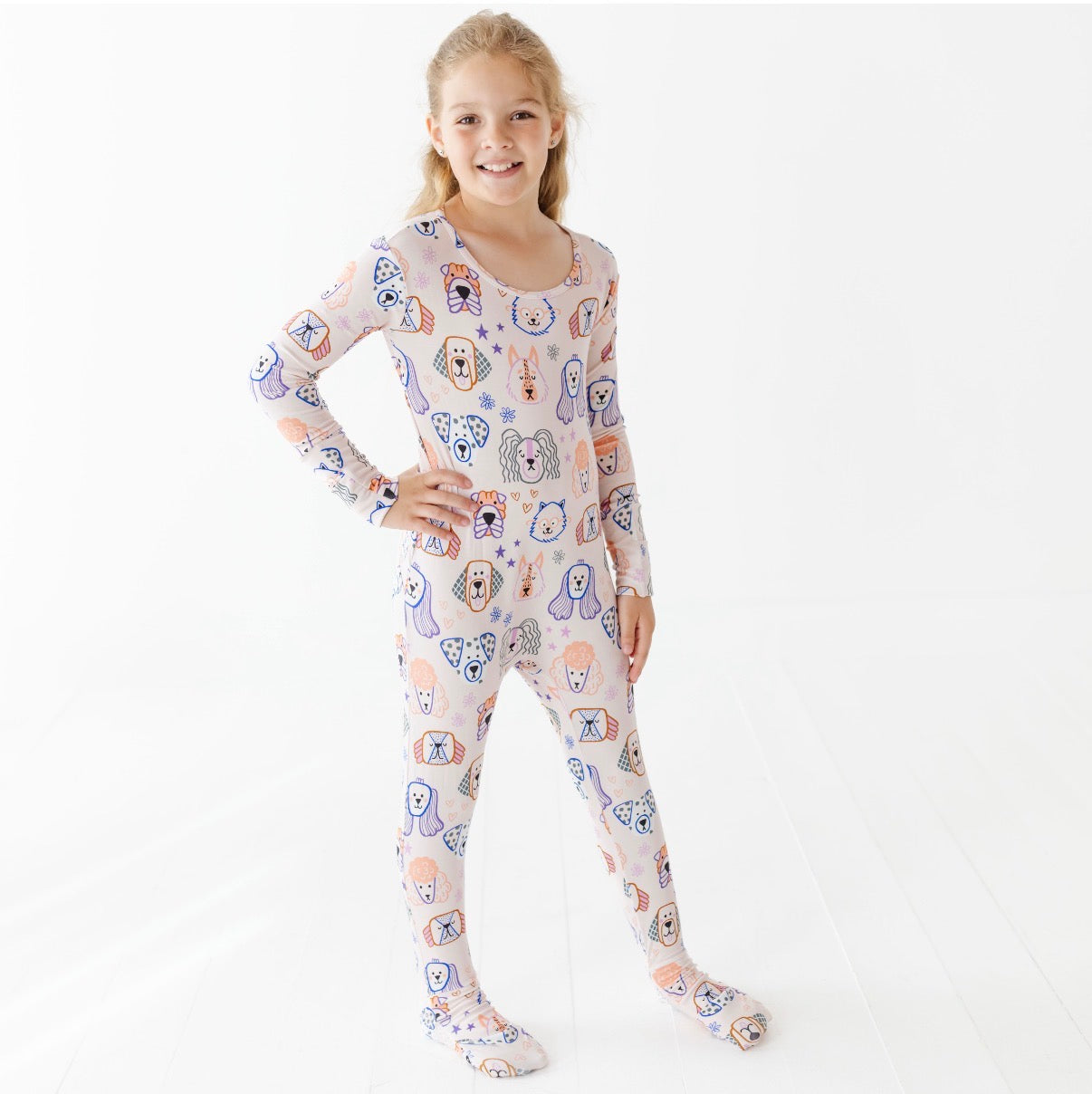 Girl wearing a patterned onesie on a white background
