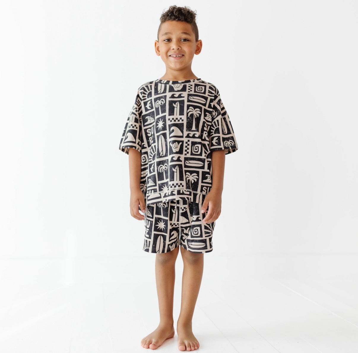Child wearing a black and white patterned cover-up on a white background