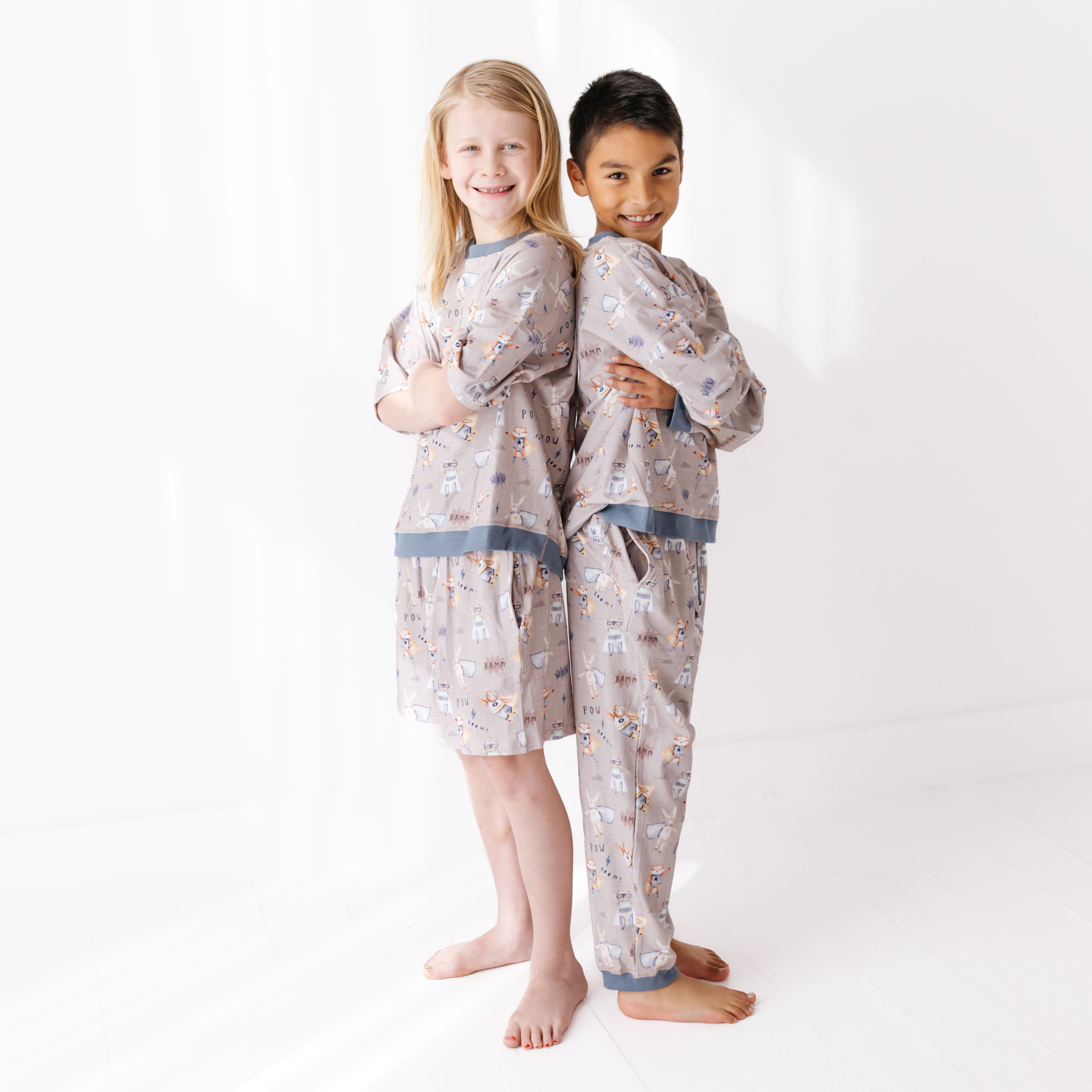 Two children wearing matching pajamas on a white background