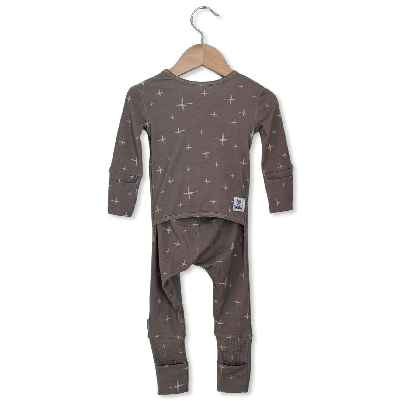 Children's pajama set with star pattern on a hanger against a white background