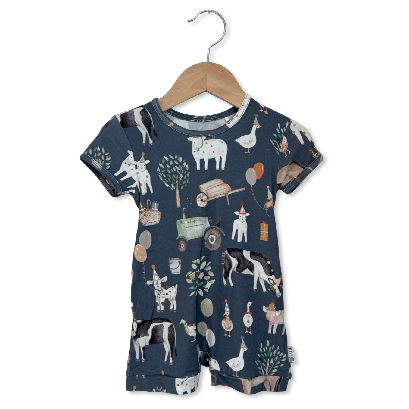 Children's romper with animal pattern on a hanger against a white background