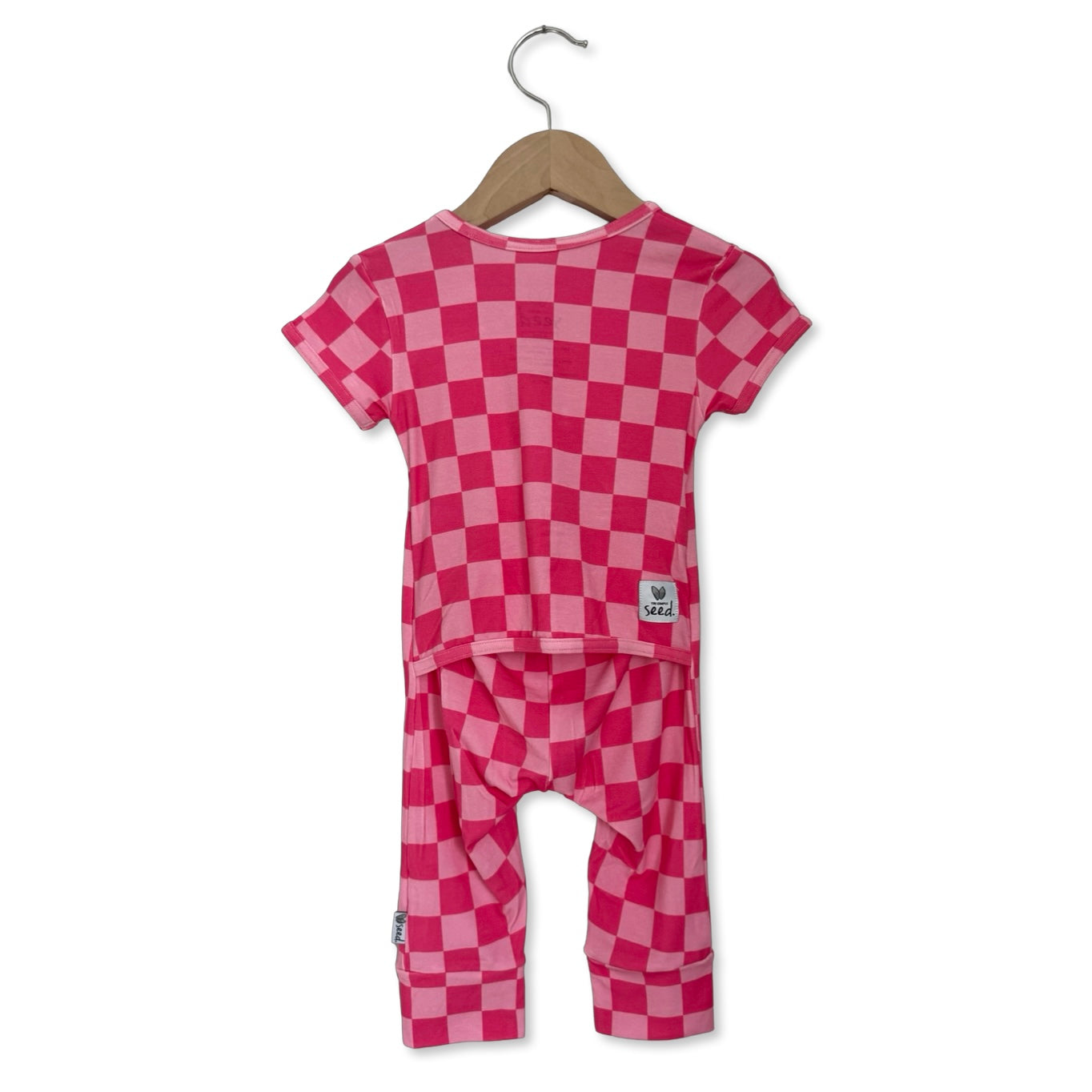 Pink checkered outfit with top and pants on a hanger against a white background