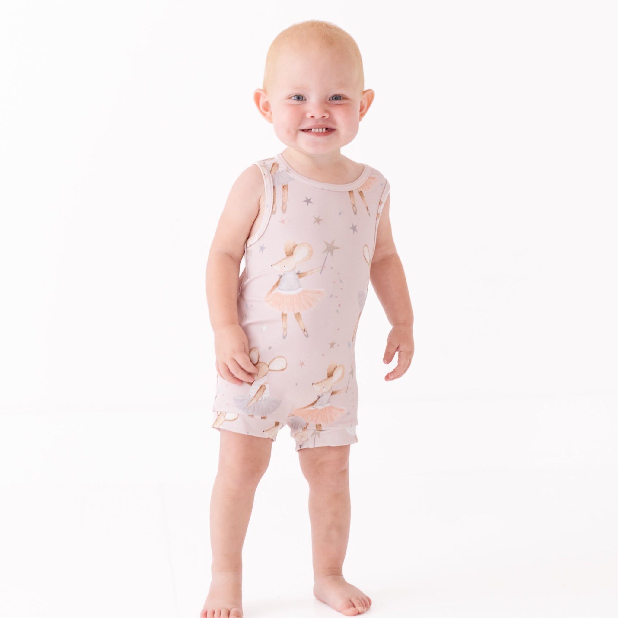 Baby wearing a sleeveless romper with animal print on a white background