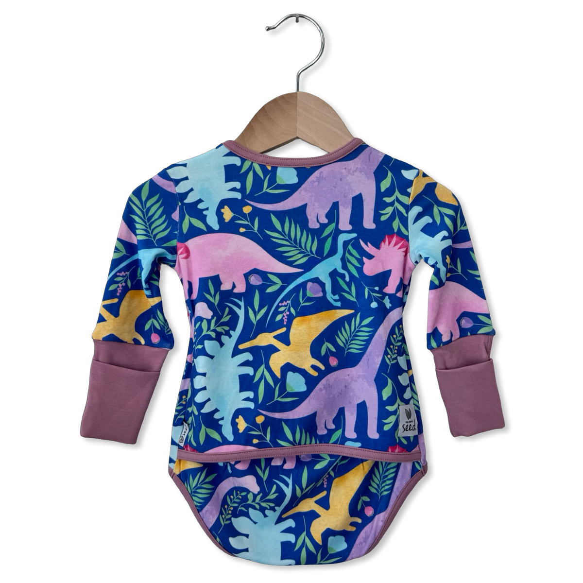 A baby long-sleeve bodysuit with a colorful dinosaur pattern, hanging on a wooden hanger against a plain white background.