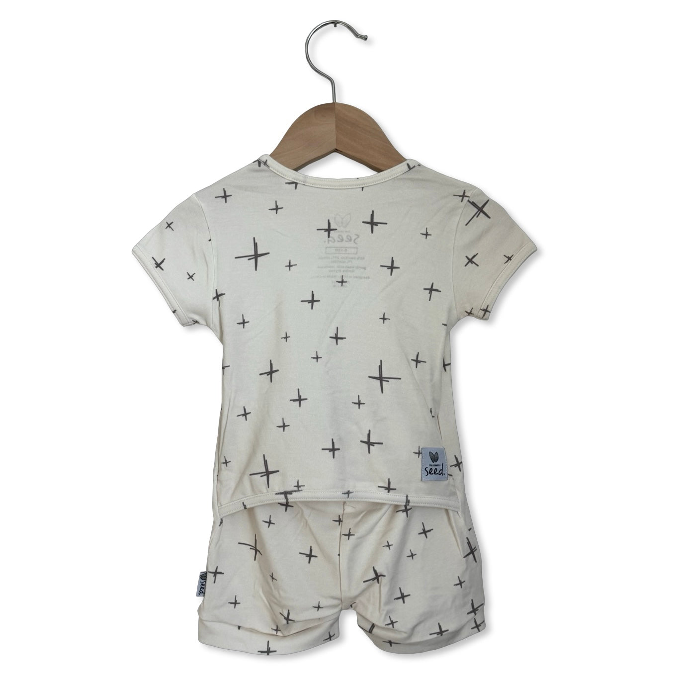 Children's outfit with patterned shirt and shorts on a hanger against a white background