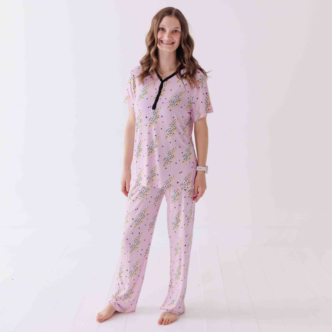 Woman wearing a pink pajama set with a white background