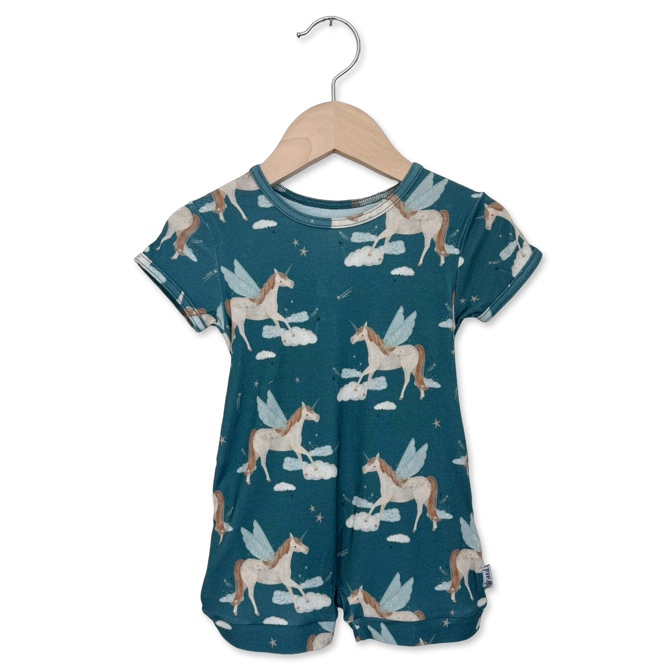 Children's romper with unicorn pattern on a hanger against a white background