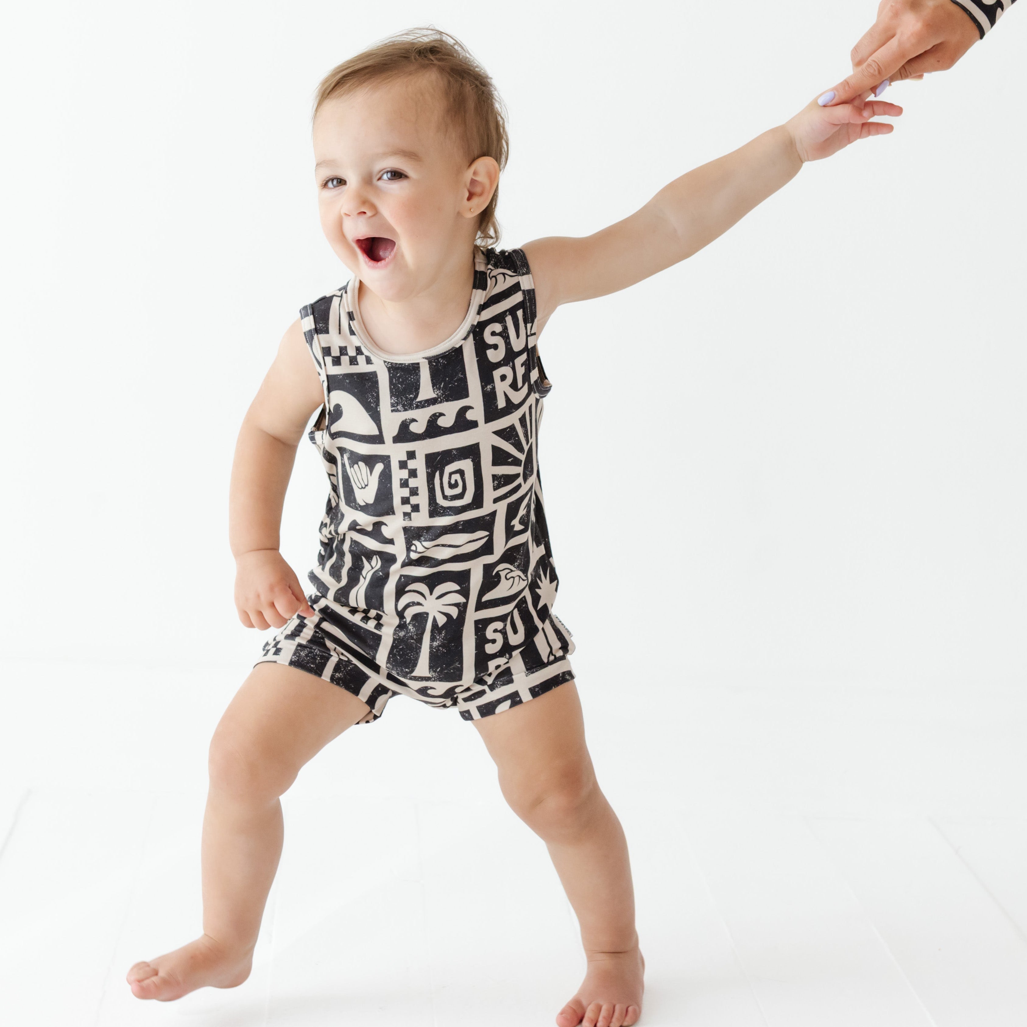 Child wearing a black and white patterned romper on a white background