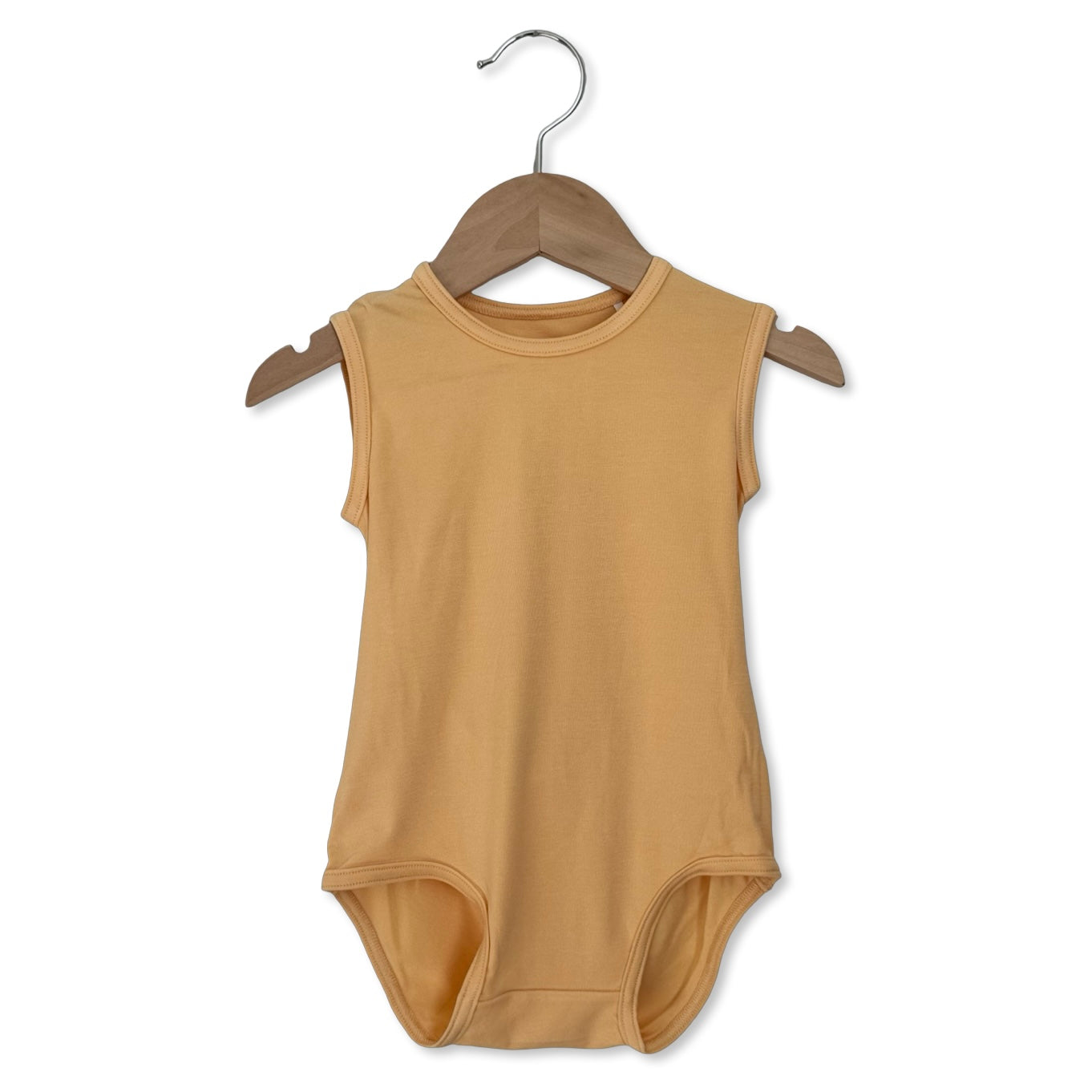 Beige sleeveless baby bodysuit on a wooden hanger against a white background
