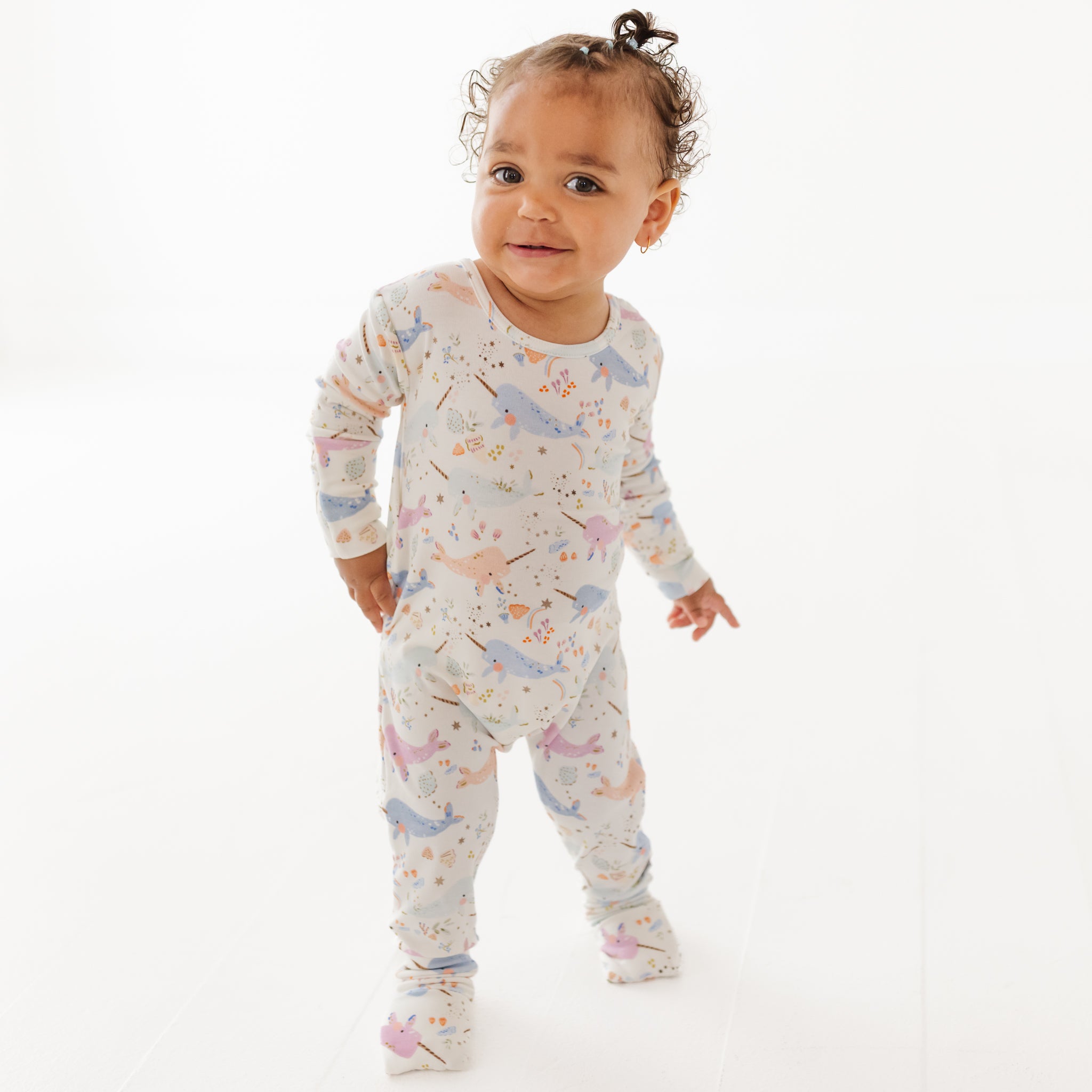 Baby wearing a onesie with animal prints on a white background