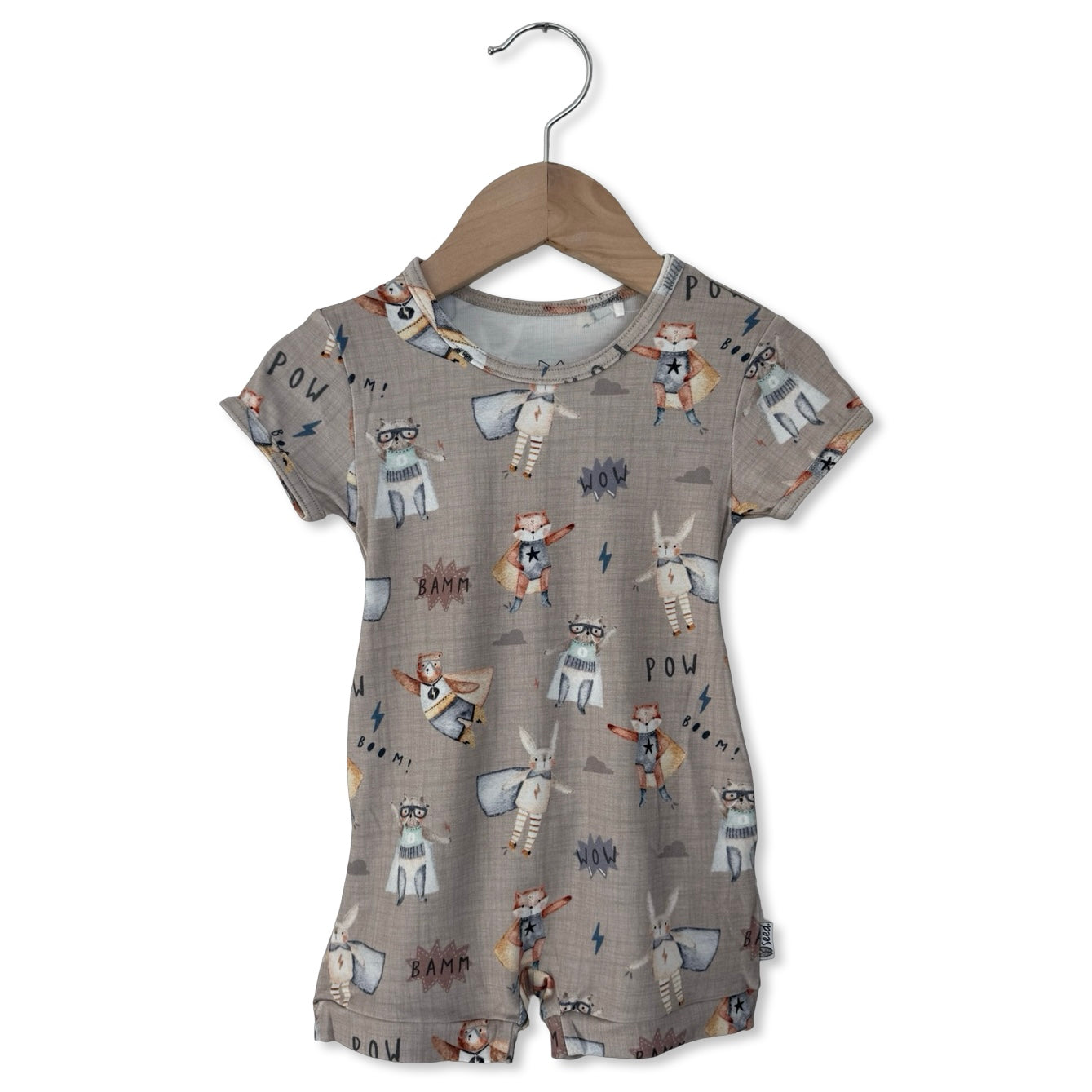 Children's romper with animal print on a hanger against a white background