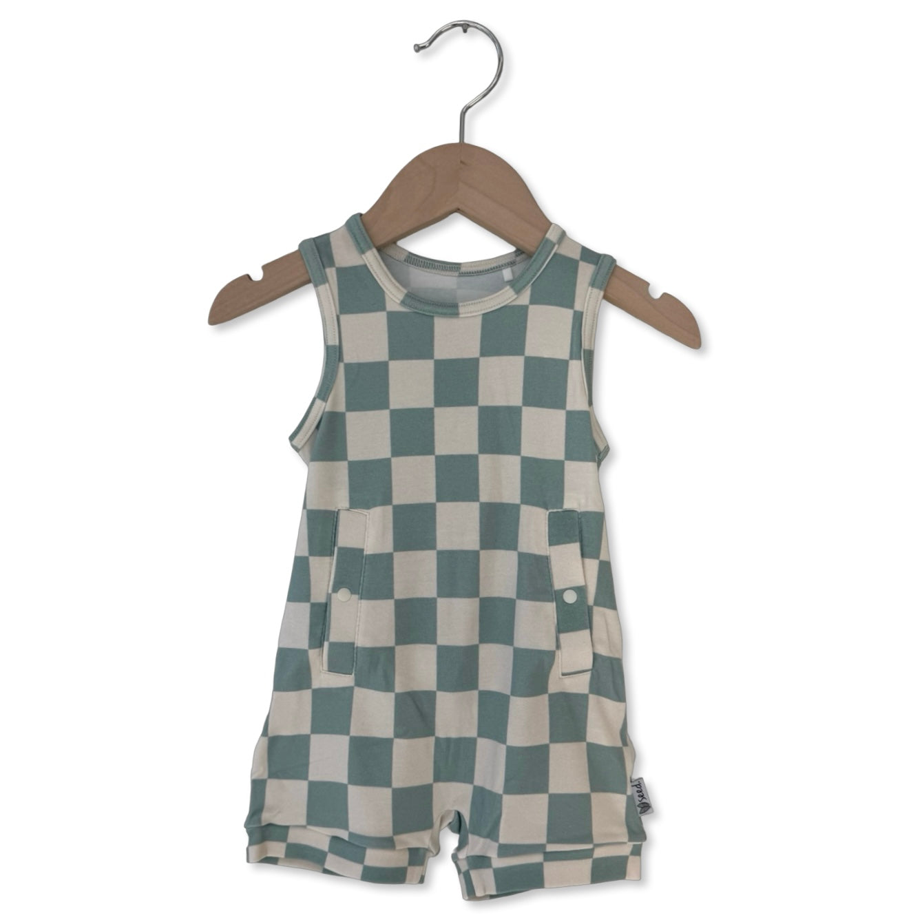 Checkered romper on a wooden hanger against a white background
