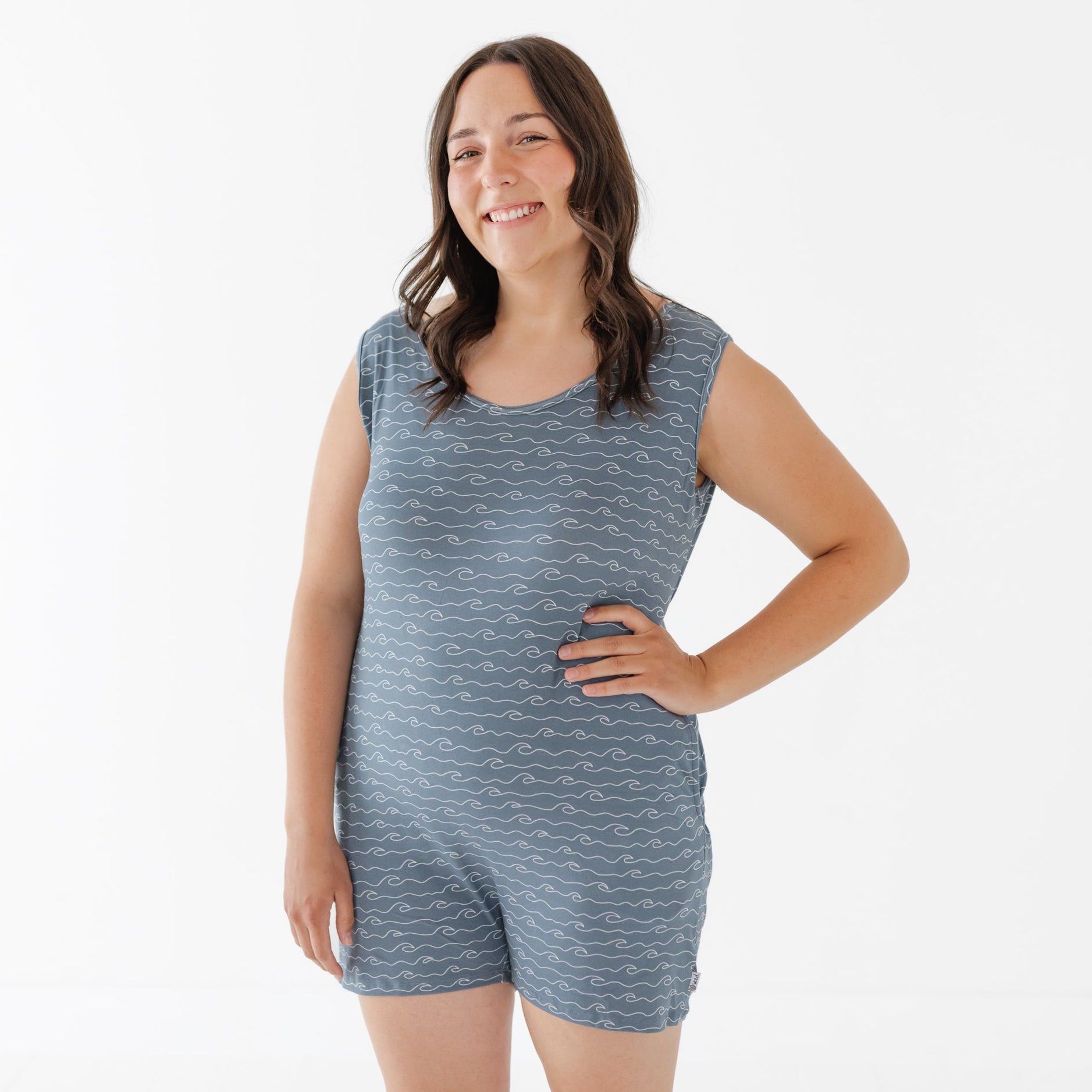Woman wearing a blue patterned sleeveless top and shorts on a white background